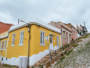 a yellow and white building on the side of a street at Sol e Rio in Setúbal
