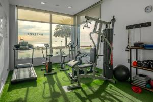 a gym with exercise equipment and a large window at Dazzler by Wyndham Puerto Madryn in Puerto Madryn