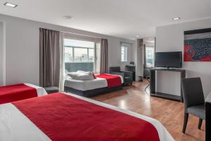 a hotel room with two beds and a flat screen tv at Dazzler by Wyndham Puerto Madryn in Puerto Madryn +156 photos