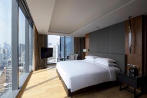 a bedroom with a white bed and a large window at Hyatt Regency Bangkok Sukhumvit in Bangkok