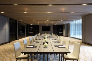 a long wooden table and chairs in a room at Hyatt Regency Bangkok Sukhumvit in Bangkok