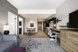 a living room and kitchen with a couch and a table at Home2 Suites by Hilton Stevens Point in Stevens Point