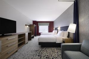 a hotel room with a bed and a flat screen tv at Home2 Suites by Hilton Stevens Point in Stevens Point +12 photos