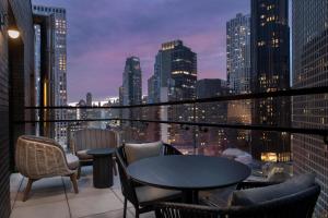 a balcony with tables and chairs and a city skyline at The Livingston, part of JdV by Hyatt in Brooklyn