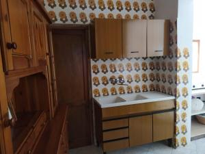 a kitchen with wooden cabinets and a sink at Tra mare e relax in Favignana
