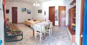 a room with a bed and a table and chairs at Tra mare e relax in Favignana