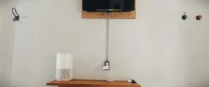 a television on top of a table with a radiator at Sleep Guesthouse in Chiang Mai