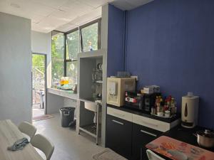 a kitchen with a blue wall with a microwave at Wayton Cottage in George Town