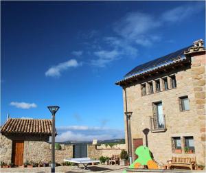 a building with a bench and a table in front of it at Cal Miger in Tiurana