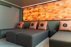 a room with two couches and a brick wall at Hotel Am Triller - Hotel & Serviced Apartments - Pool & Relax Lounge in Saarbrücken
