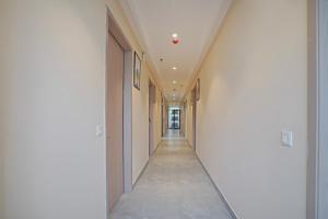 a hallway with white walls and a long corridor at Treebo Premium Indus Crown in Noida