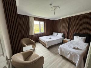 a hotel room with two beds and a chair at Lina Apart in Arnavutköy