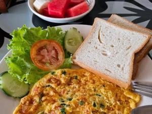 a plate of food with a omelet and bread and a salad at Meesokxay Hotel Vang Vieng in Vang Vieng +23 photos