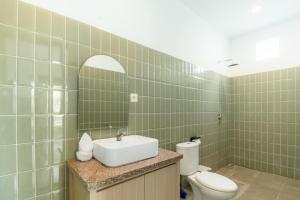 a bathroom with a sink and a toilet and a mirror at Casa Lumina Canggu in Canggu +15 photos