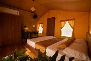 a bedroom with a bed and a table in it at Vanantara Riverside Eco Retreat in Cochin