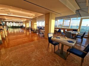una sala da pranzo con tavoli e sedie in un edificio di City Hotel a Senigallia