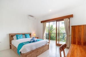 a bedroom with a bed and a balcony at Casa Lumina Canggu in Canggu