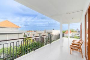 a balcony with a bench and a view of the city at Casa Lumina Canggu in Canggu