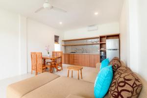 a living room with a couch and a kitchen at Casa Lumina Canggu in Canggu