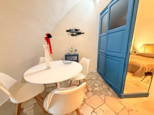a white table and chairs in a room with a blue door at Suite Del Borgo in Gallipoli