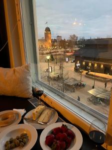a table with plates of food and a window at Top location in Joensuu in Joensuu