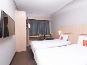 a hotel room with two beds and a desk at ibis Medellin in Medellín +84 photos