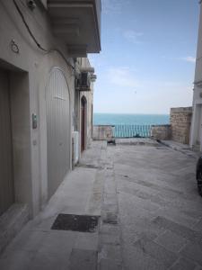 an empty alley way with the ocean in the background at Dal Nadìr allo Zènit room in Polignano a Mare