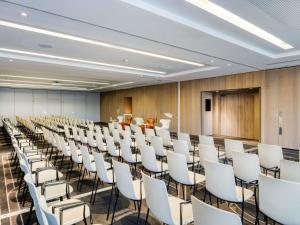 a conference room with white chairs and a podium at Pullman Brussels Centre Midi in Brussels