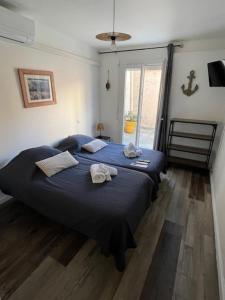 a bedroom with a blue bed with towels on it at Hotel de la plage in Banyuls-sur-Mer