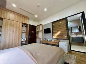 a bedroom with a bed and a desk and a tv at Quiri Lakeside Hotel Cat Ba in Cat Ba