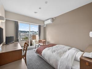 a hotel room with a bed and a desk and a window at Hitachi Ocean View HOTEL and RESORT in Hitachi +30 photos