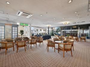 a lobby with tables and chairs in a building at Hitachi Ocean View HOTEL and RESORT in Hitachi