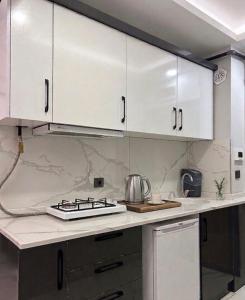 a kitchen with white cabinets and a stove at Velora Suit Hotel in Nevşehir