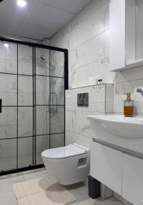 a white bathroom with a toilet and a sink at Velora Suit Hotel in Nevşehir