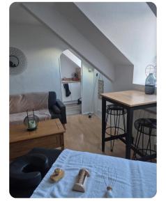 a living room with a bed and a table at Le petit duo in Saint-Brieuc