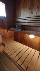 a wooden bed in a cabin with a window at kelankaari in Kankaanpää
