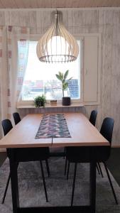 a dining room table with chairs and a chandelier at kelankaari in Kankaanpää +9 photos