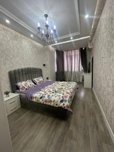 a bedroom with a bed and a chandelier at Luxanda Samarkand in Samarkand