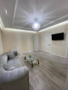 a living room with a couch and a flat screen tv at Luxanda Samarkand in Samarkand