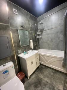 a bathroom with a sink and a tub and a toilet at Luxanda Samarkand in Samarkand