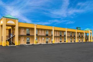 a large yellow motel building with a parking lot at Quality Inn White Springs Suwanee in Live Oak