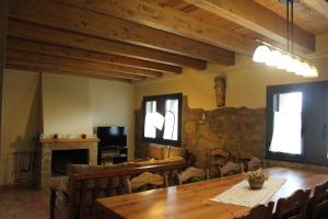 a dining room with a table and a fireplace at Cal Miger in Tiurana