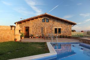 a stone house with a pool in front of it at Cal Miger in Tiurana