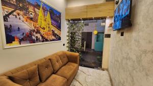 a brown couch in a room with a large painting at Hotel RK Heritage in Varanasi
