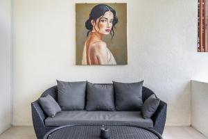 a couch in a room with a painting of a woman at Dreamland Suites - Walk to Dreamland Beach in Uluwatu