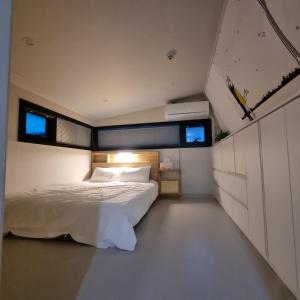 a bedroom with a white bed and two windows at YYStay 감성 루프탑 in Seoul +54 photos