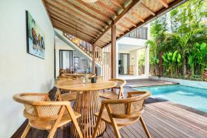 an outdoor dining area with a table and chairs and a pool at Dreamland Suites - Walk to Dreamland Beach in Uluwatu