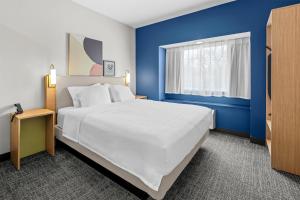 a bedroom with a large white bed and blue walls at Spark by Hilton Stillwater in Stillwater +45 photos