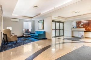 a living room with a blue couch and chairs at Comfort Inn & Suites Saint Louis Lafayette Square in Saint Louis