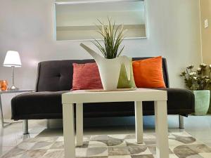 a living room with a couch and a table with a plant at Pacific Staycation in Kaybagal